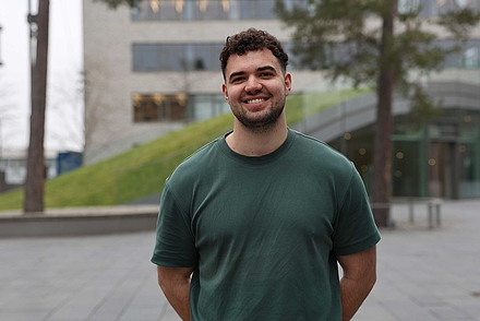 Auf dem Foto sieht man den neuen Studenten Leon Müller im grünen T-Shirt vor der Mensa am Bildungscampus in Heilbronn 