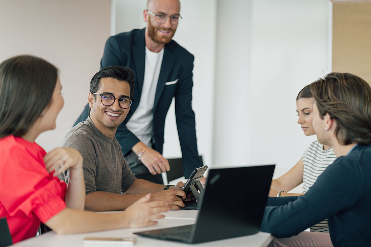 internationale Studierende sitzen an einem Tisch und unterhalten sich