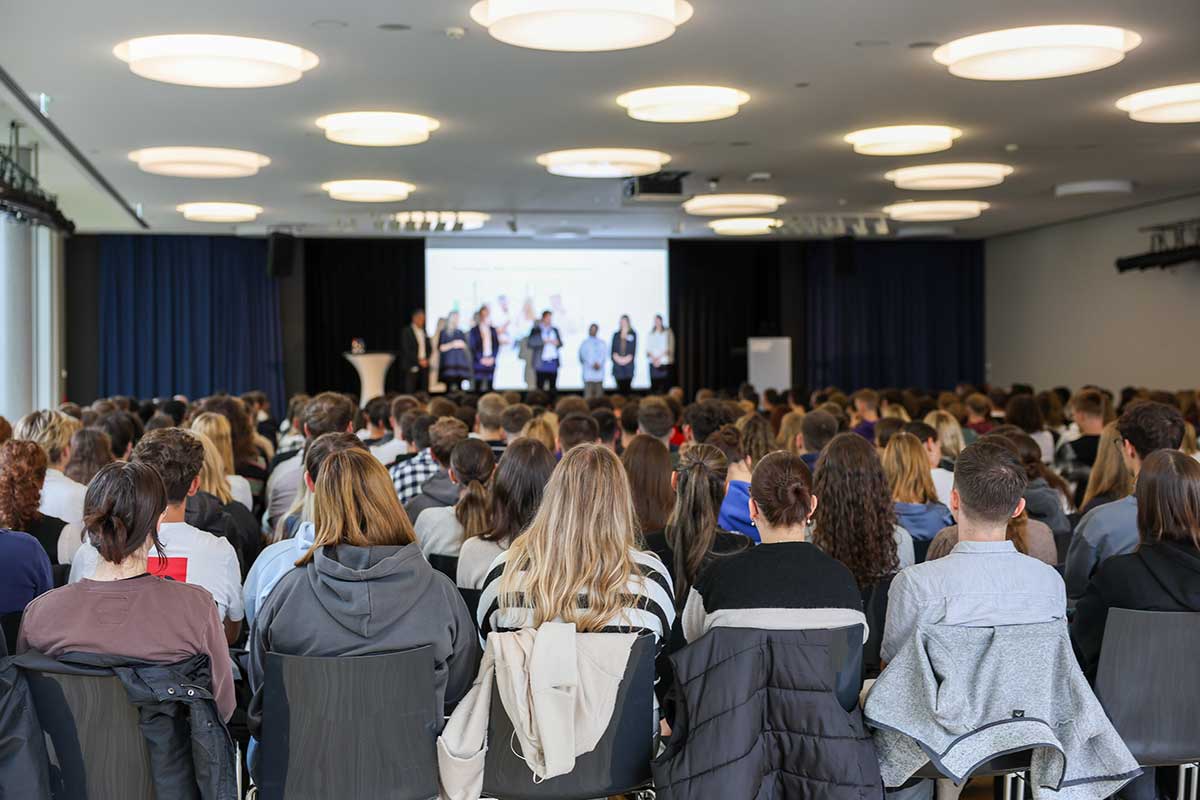 Die Erstsemester 2024 bei ihrer Begrüßung im Forum auf dem Bildungscampus von hinten fotografiert