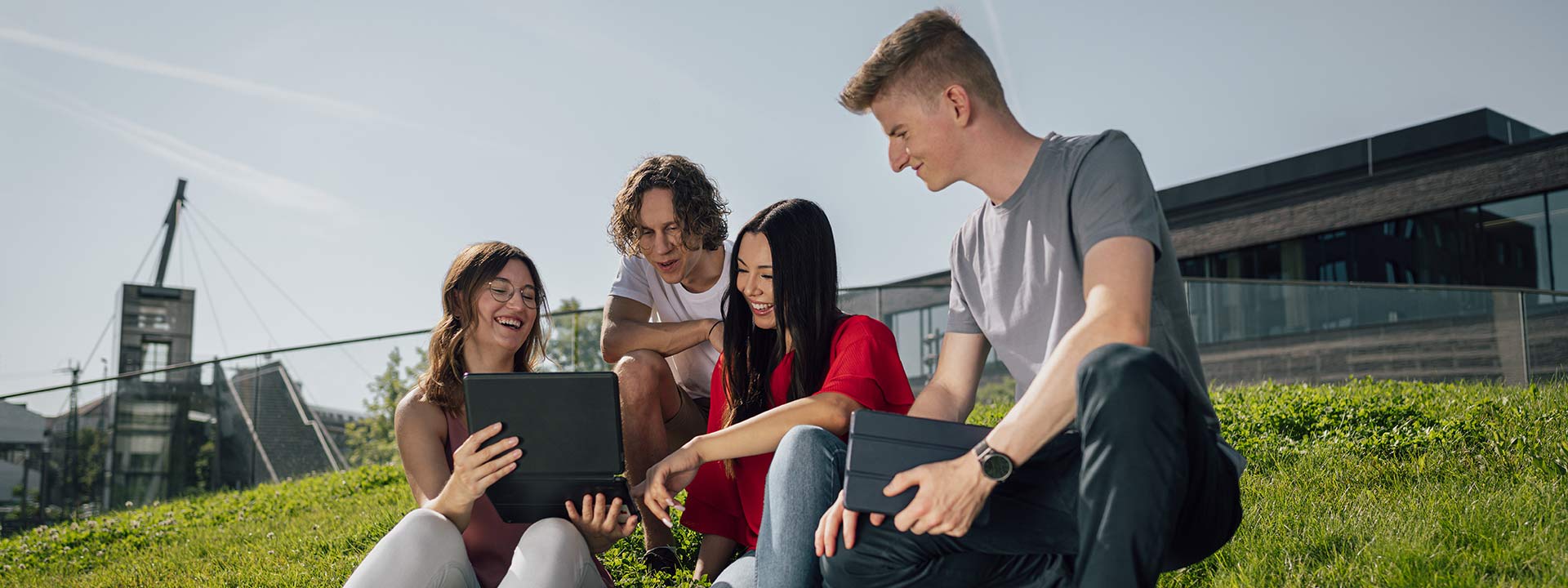 Steinheisser_Last-Minute_Studienplätze Studierende auf dem Mensahügel auf dem Bildungscampus, die sich etwas am Laptop anschauen